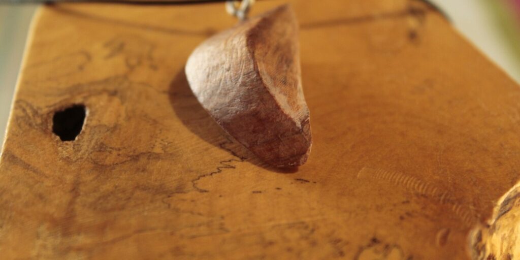 Pendentif en bois en forme de croissant, sur cordon noir