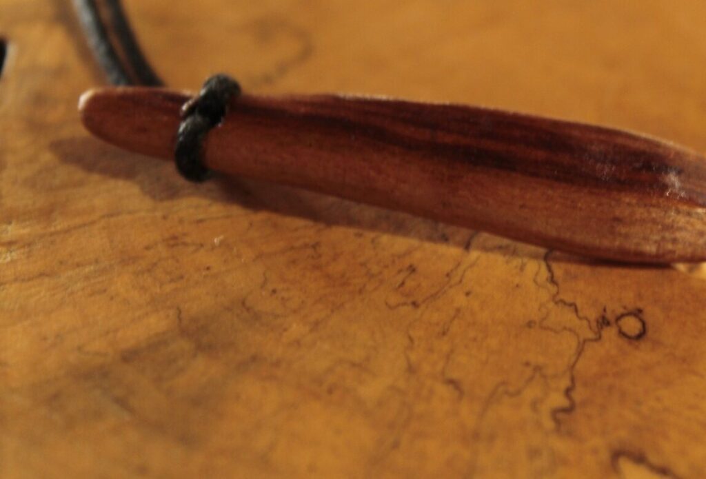 Pendentif en forme de feuille, bois brun lustré, sur cordon noir