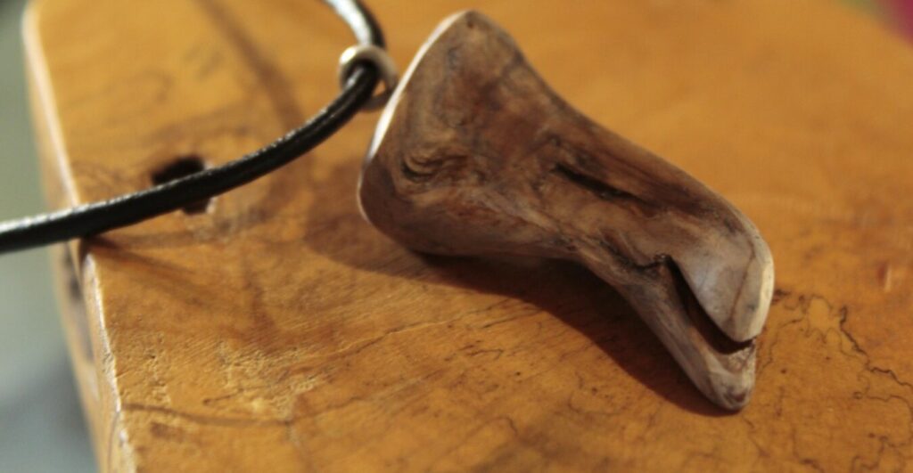 Pendentif en bois aux formes arrondies et au grain marqué