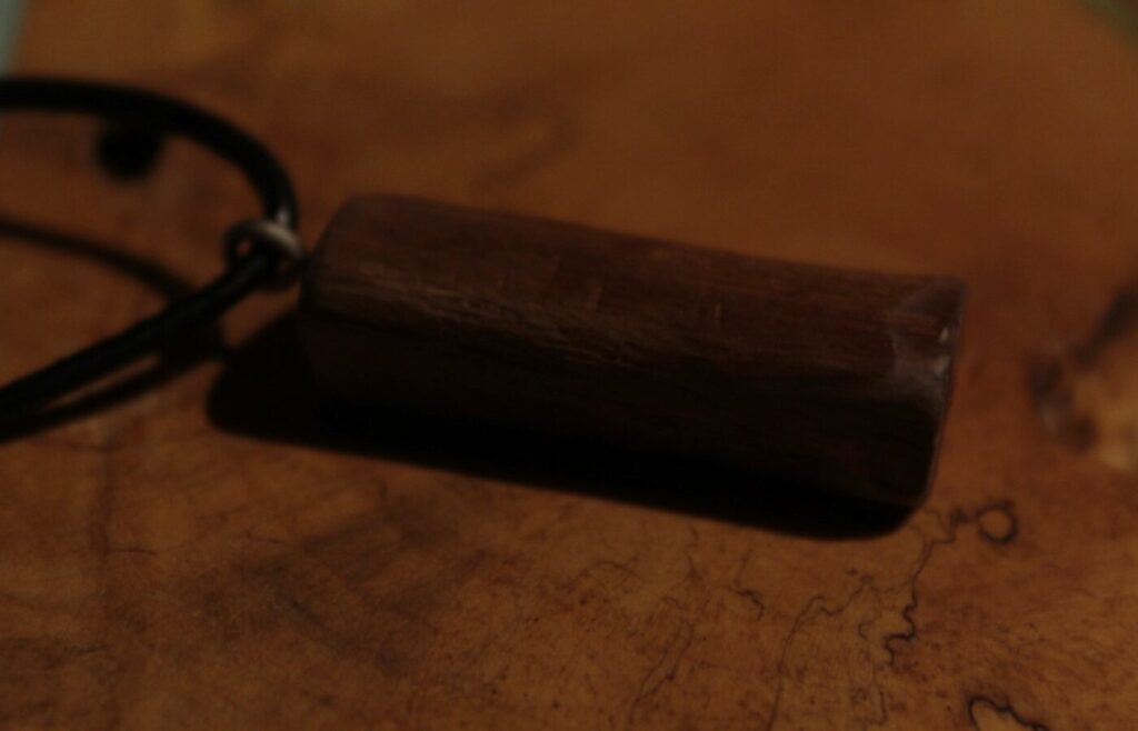 Pendentif lingot en bois sombre, sur cordon noir