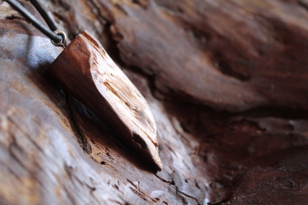 Pendentif en pointe en bois brut, surface laissée naturelle